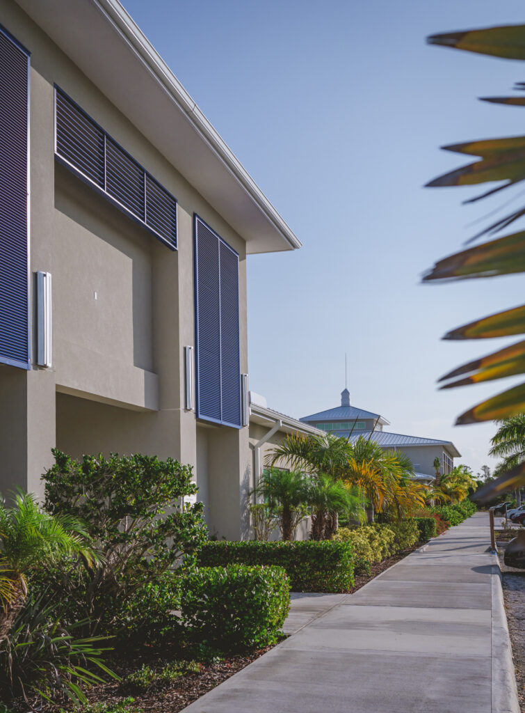 The WAUSM campus building in Freeport, Grand Bahama, with palm trees and tropical landscaping under a clear blue sky.